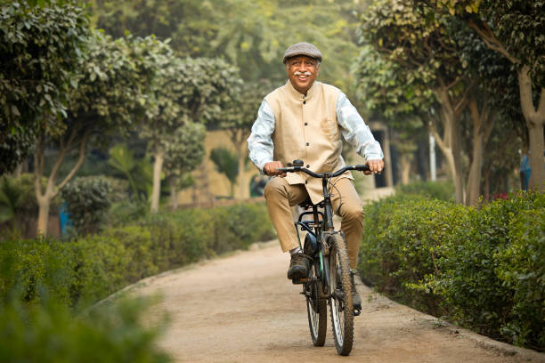 istock Happy old man riding bicycle on garden path 1455154909