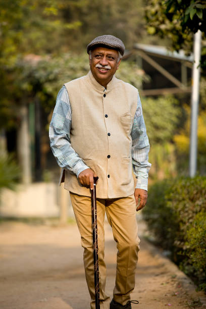 istock Older man with walking stick at park 1455155019