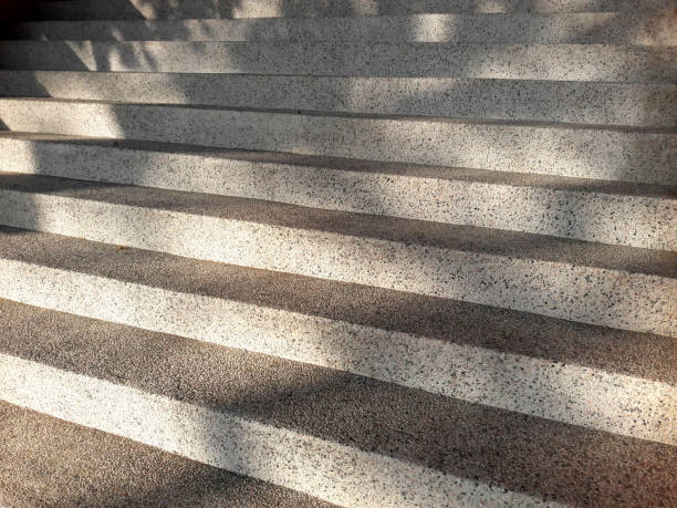 istock Abstract cement or concrete texture of stairs or steps. Diagonal stripes or lines pattern for background. Leaf reflections on the stairs. 1455158340