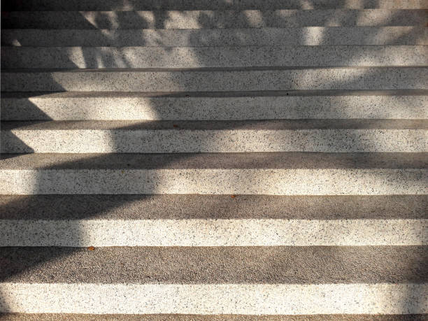 istock Abstract cement or concrete texture of stairs or steps. Diagonal stripes or lines pattern for background. Leaf reflections on the stairs. 1455158341