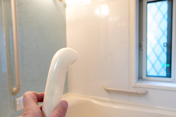 istock Holding a shower head in the bathroom 1455159771