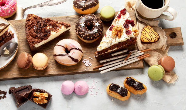 istock Table with various cakes, cookies, donuts and coffe cups on light background. 1455160760