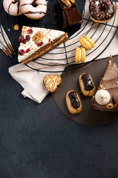 istock Table with various cookies, donuts, cakes, cheesecakes on dark background. 1455161395