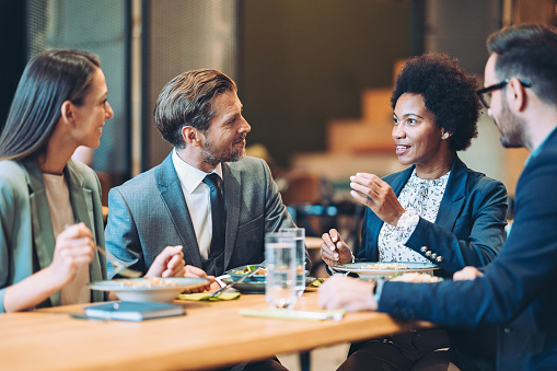 Multiracial group of business persons talking in a restaurant