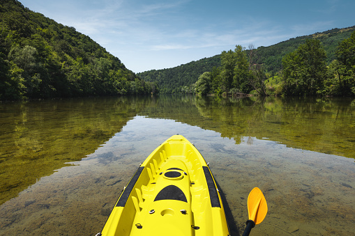 Yellow kayak in calm waters of Kolpa River.