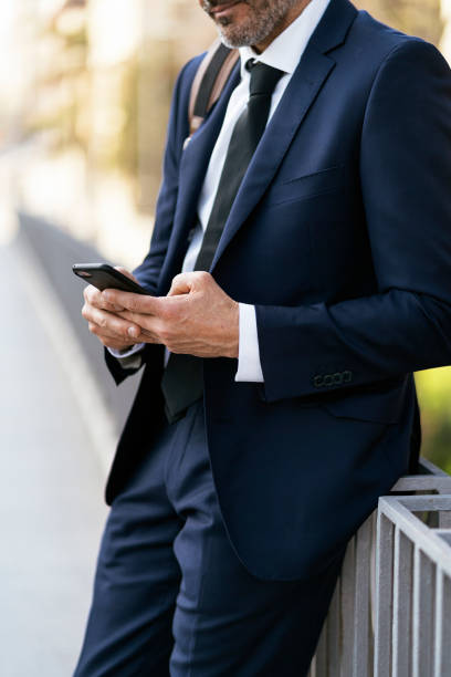 istock Crop businessman using smartphone on street 1455173399