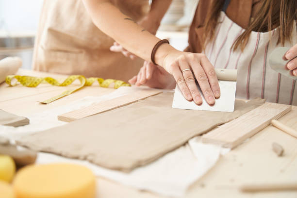 istock Women wearing aprons in a ceramics workshop creating clay pieces. 1455178184