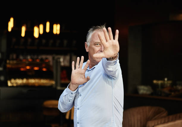 istock Keep out! Bar manager or bouncer makes the stop gesture, indicating that you are not welcome 1455178205
