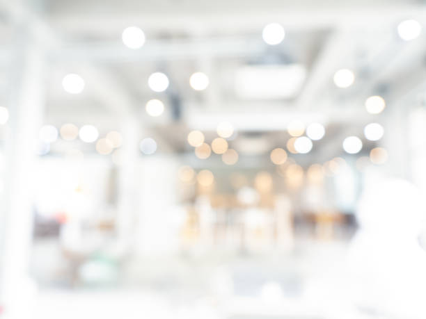 istock Abstract blurred modern workspace hall background, white indoor interior office or working space with window and the ceiling light bikeh. Blurry backgrounds for advertising and business presentation. 1455179303