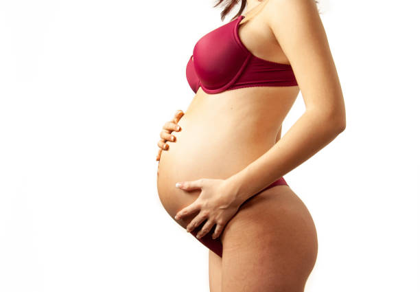 side view of pregnant young woman touching her belly