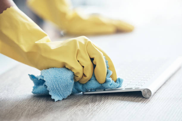 istock Cleaning service, keyboard computer and hands with cloth for office policy, compliance and covid healthcare in workspace. Modern office desk, workplace and cleaner clean dust or bacteria from desktop 1455182943