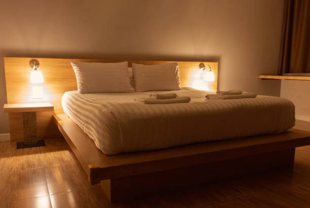 istock white pillows and blanket in bed with light from lamps at night 1455184161