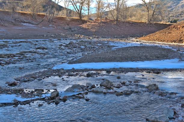 istock Field covered with frozen river with rocky mountains in the background 1455189363