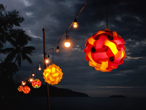 The colorful lanterns in red, orange and yellow on a beach in Thailand at night