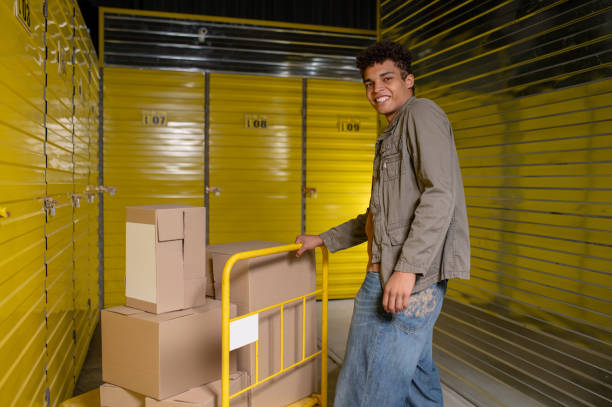 istock Young curly-haired man in a warehouse with many boxes 1455195353