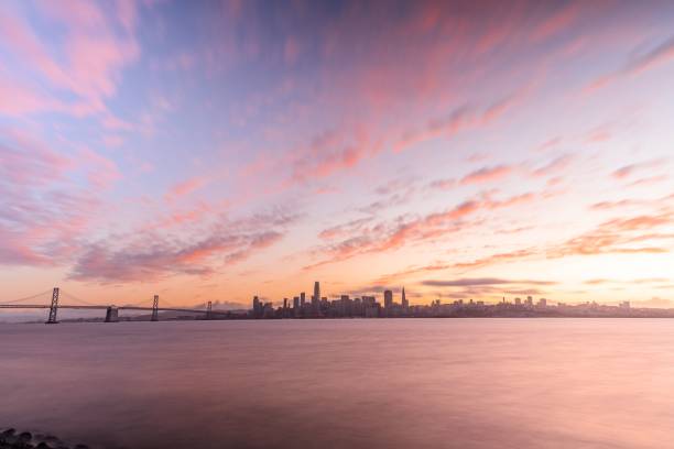 piękna scena wieczornej panoramy san francisco i mostu bay bridge na fioletowym niebie zachód słońca, kalifornia, usa - sun lighting equipment san francisco county downtown district zdjęcia i obrazy z banku zdjęć