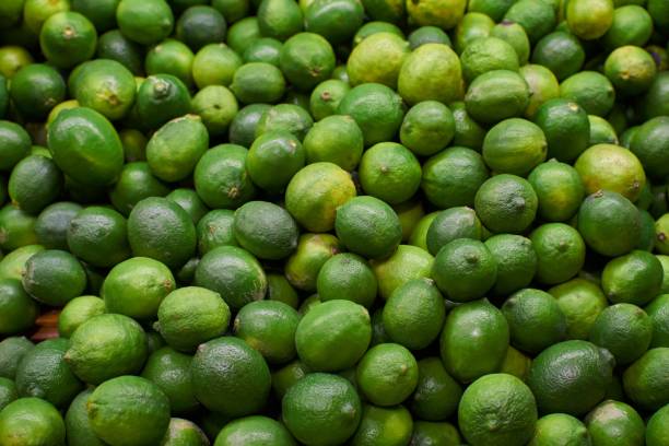 istock Green lemons placed on a shelf for sale 1455196583