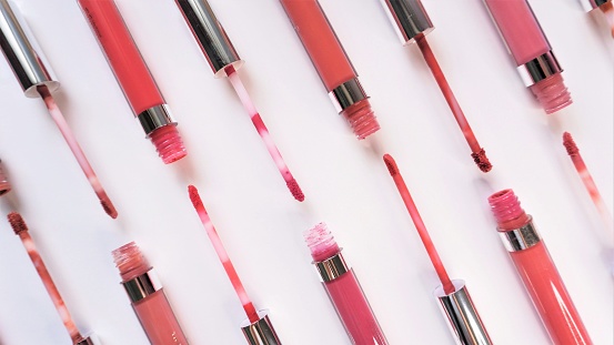 Liquid lipstick artistic layout. Makeup store minimal display on white background.