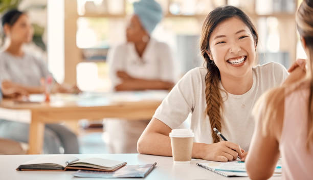 istock Business women, bonding and coffee break planning with documents, kpi research or target audience data analysis for creative startup. Smile, happy student and asian designer in teamwork collaboration 1455198297