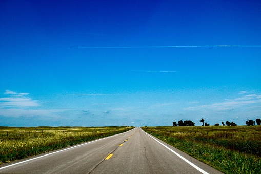A beautiful view of a highway passing through fields on a sunny day in a rural area of Nebraska, United States