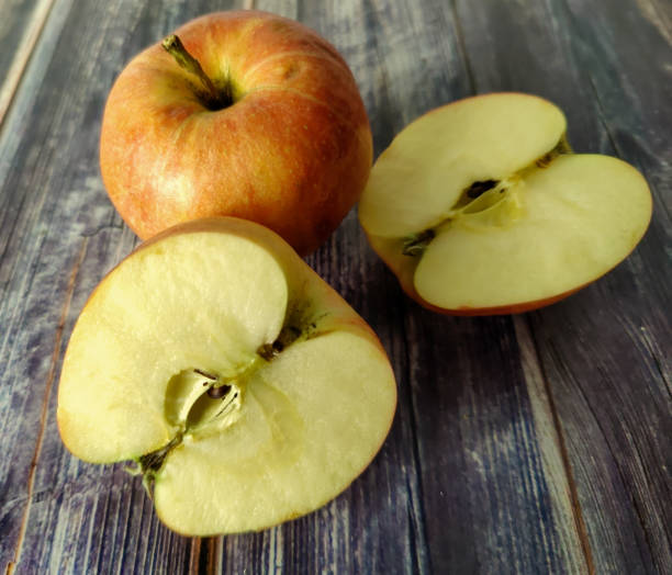 istock Whole red apple and two half on a wooden table 1455200553