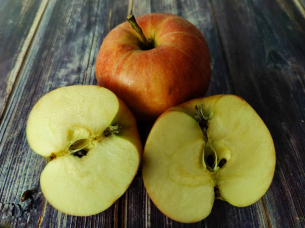 istock Whole red apple and two half on a wooden table 1455200875