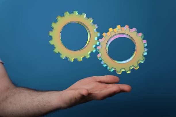 istock 3D rendered gears icons hovering over a man's palm on a blue background 1455202073
