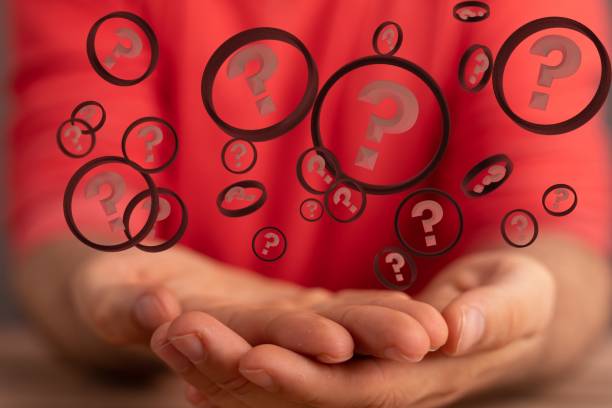 istock Person's hand with illustrative question mark icons floating above hands. 1455202966