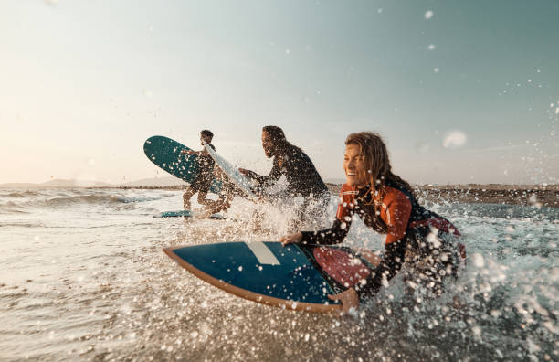 istock Cheerful surfers having fun while surfing in sea. 1455203314