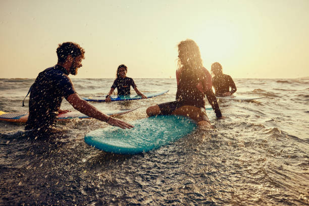istock Cheerful surfers having fun in sea at sunset. 1455203748