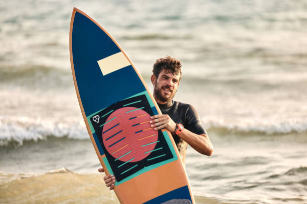 istock Young male surfer carrying surfboard on the beach. 1455203789