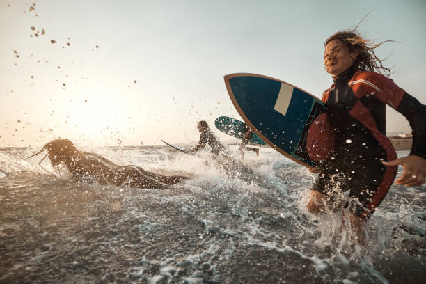 istock Carefree surfers having fun while surfing in sea at sunset. 1455203894