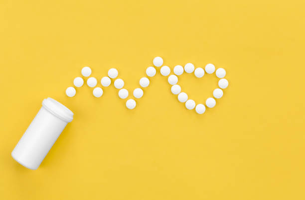 istock Scattered heart shaped pills on yellow background, flat lay. 1455207130