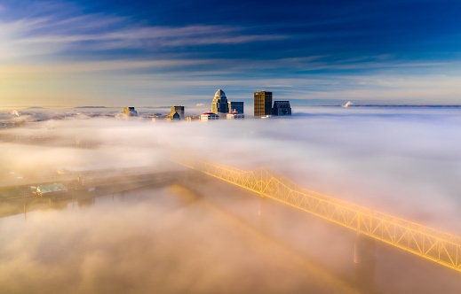 An aerial view of a modern city in fog on the sunrise