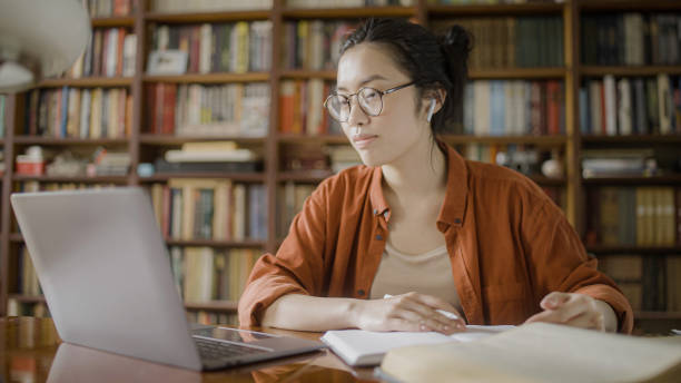 istock Young asian teacher giving online classes using laptop at university library 1455208307