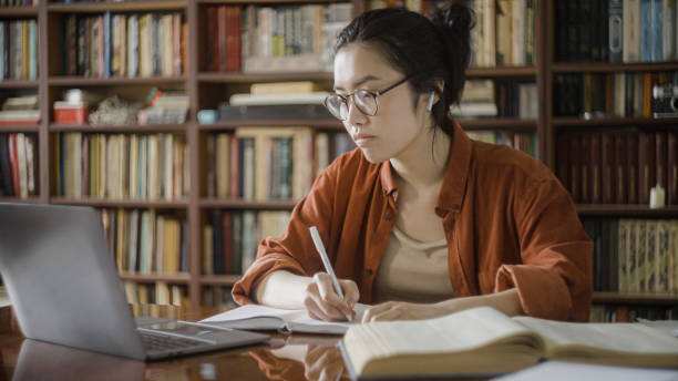 istock Tired woman asian student taking notes from online course, distance education 1455208629