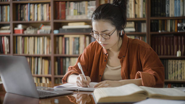 istock Tired young woman studying in a library, overburdened with work, academic pressure 1455208631
