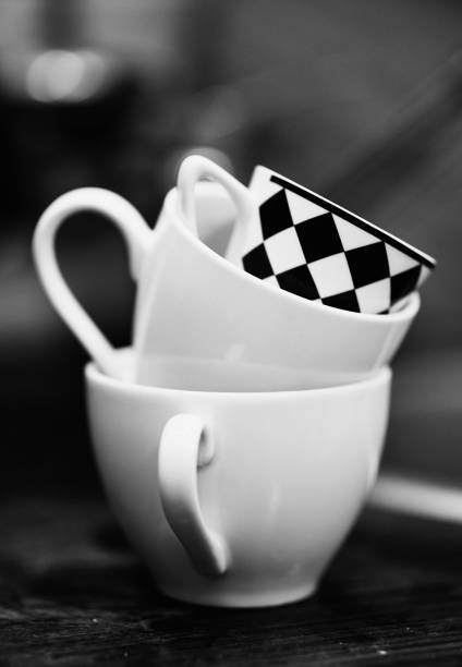 istock Grayscale shallow focus of white marble cups and a white and black checked cup, blurred background 1455209582