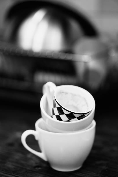 istock Grayscale shallow focus of white marble cups and a white and black checked cup, blurred background 1455209584
