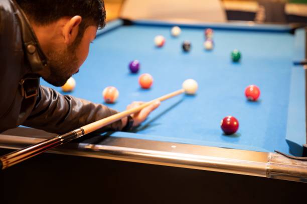istock young man playing billiard game ( pool game ) at indoor club 1455209770
