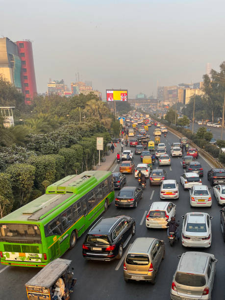 istock Image of traffic jam on motorway viewed from overpass, motorbikes with pillion passengers, buses, cars, auto rickshaws stationary on highway, main road with striped barrier, focus on foreground 1455210290
