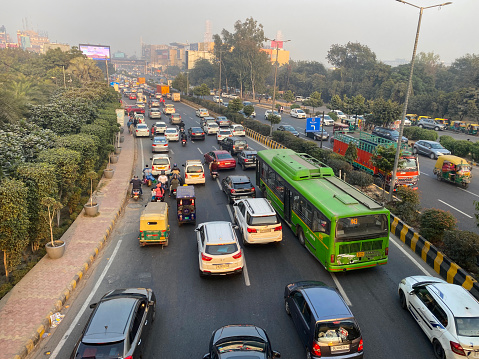 Stock photo showing view from overpass of traffic with motorcycles, cars and auto rickshaws seen gridlocked in a traffic jam running bumper to bumper on multilane highway.