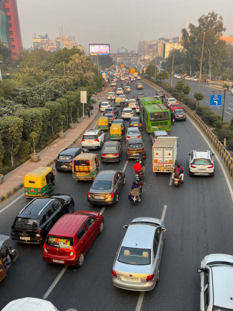istock Image of traffic jam on motorway viewed from overpass, motorbikes with pillion passengers, buses, cars, auto rickshaws stationary on highway, main road with striped barrier, focus on foreground 1455210325