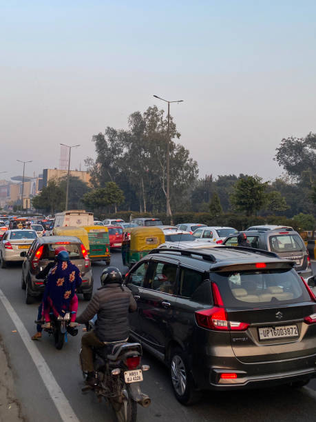 istock Close-up image of traffic jam on motorway viewed from overpass, motorbikes with pillion passengers, buses, cars, auto rickshaws stationary on highway, main road with striped barrier, focus on foreground 1455210328