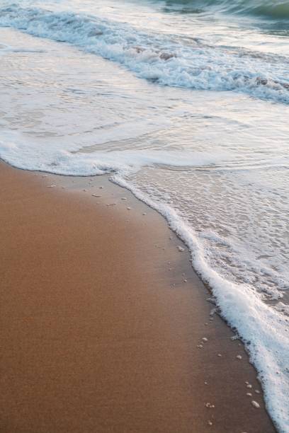 istock Close up of waves rolling in on a sandy 1455211476