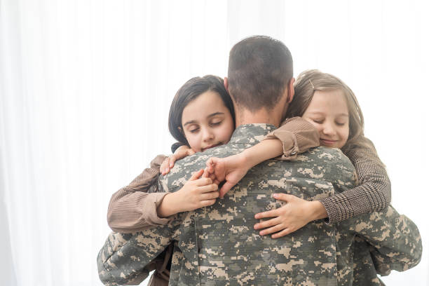 istock Happy military father and two daughters at home. 1455211621