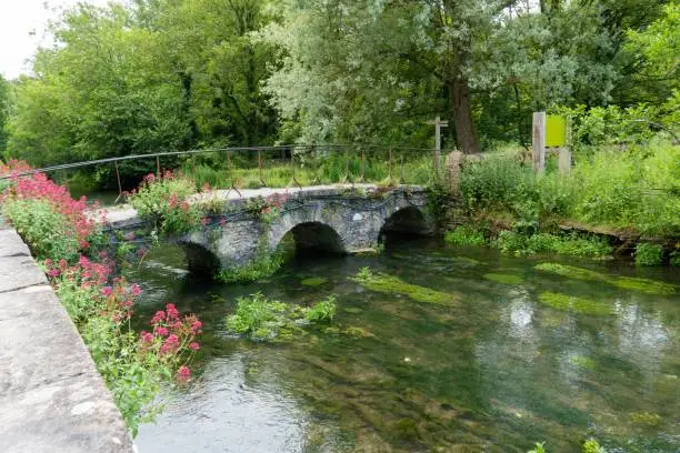 The beautiful stone footbridge covered with flowers. Bibury, England, UK.