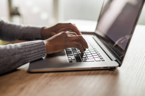 istock Young woman typing data on a laptop with blank, white screen 1455212805