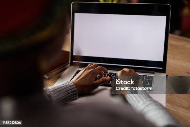 Young Woman Typing Data On A Laptop With Blank White Screen Stock Photo - Download Image Now