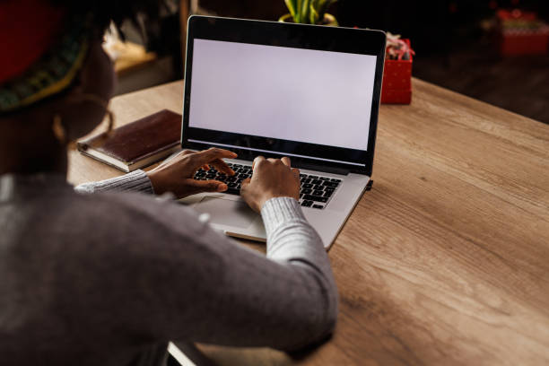istock Young woman typing data on a laptop with blank, white screen 1455212807